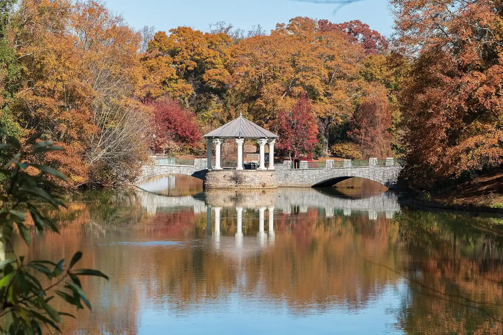 The gazebo on the bridge over Lake Clara Meer in Piedmont Park, Atlanta, ringed by fall color